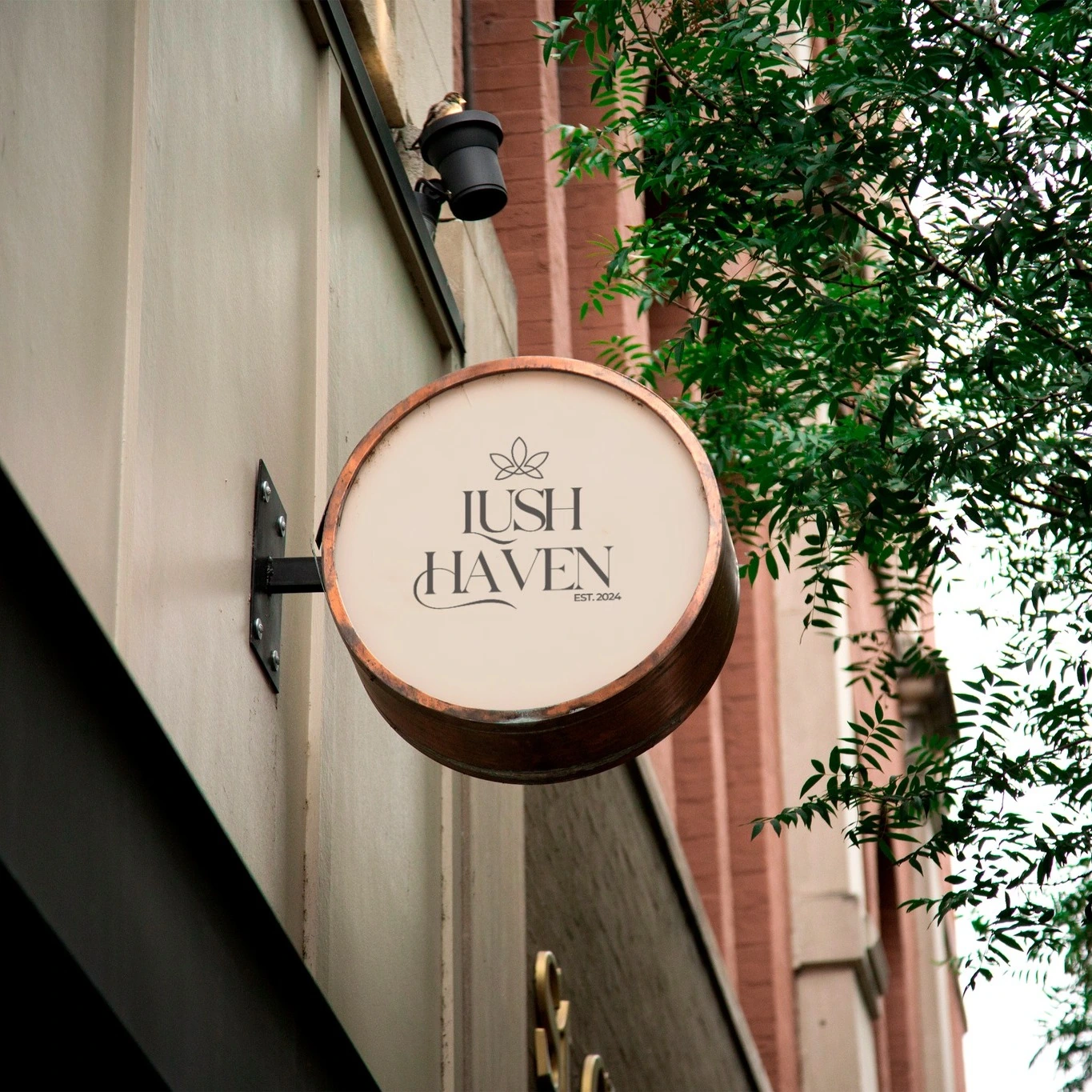 Lush Haven circular sign mockup outside a building with greenery